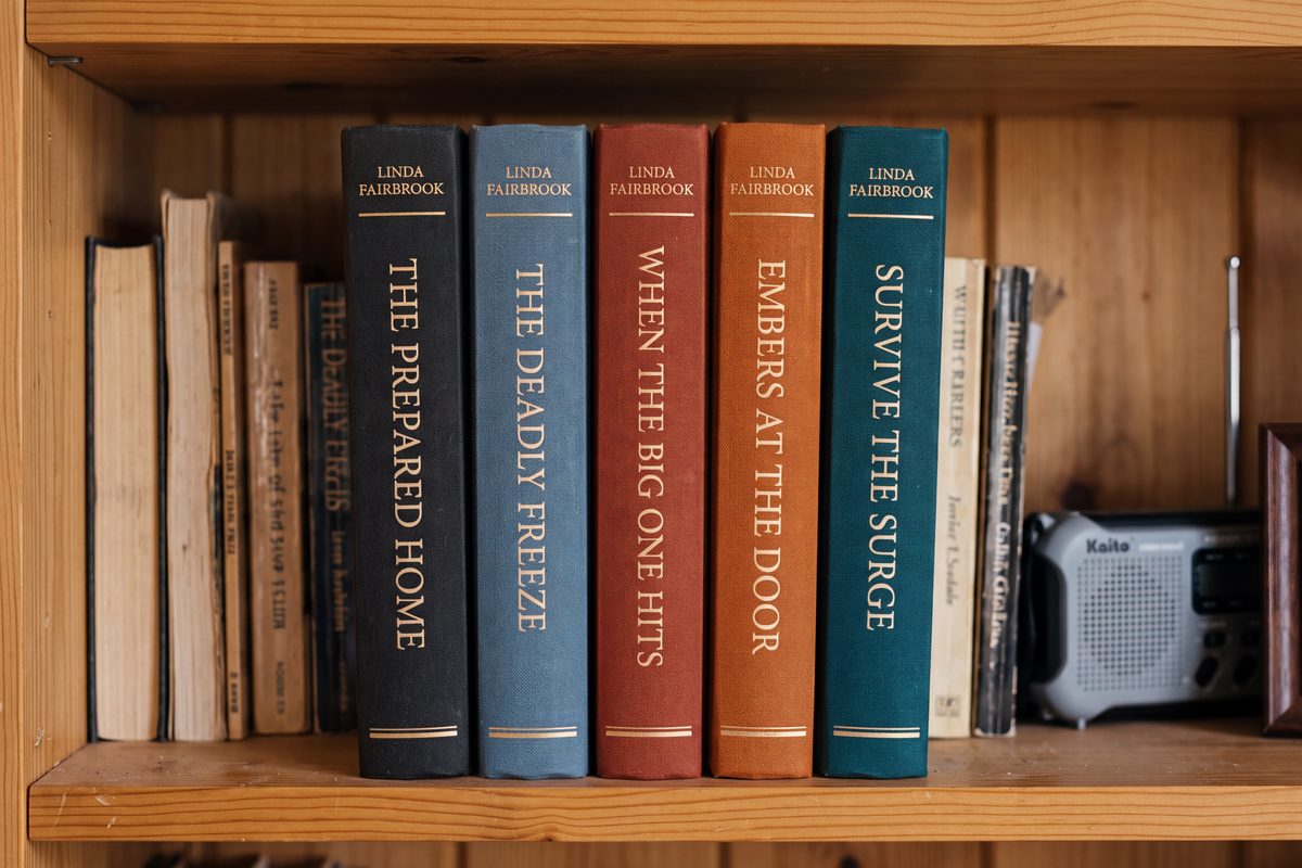 The five books on Linda's shelf beside the weather radio